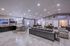 Contemporary, spacious living area with chic gray tones, stylish seating, and modern lighting, perfect for entertaining and relaxation.