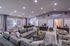 Luxurious lounge with modern decor, featuring plush grey sofas, chic patterned armchairs, and ambient lighting perfect for relaxation and conversation.