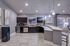 Modern kitchen with sleek dark cabinetry, stylish breakfast bar, and ambient pendant lighting.