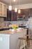 Modern kitchen with elegant granite countertops, stylish bar stools, stainless steel appliances, and warm pendant lighting.