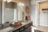 Luxurious bathroom with elegant granite countertop, twin sinks, and modern art decor, leading to a spacious walk-in closet.