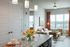 Chic modern living area with granite kitchen island, vibrant tulip centerpiece, and cozy seating by large sunlit windows.
