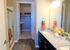 Elegant bathroom with granite countertop, double sinks, glass shower, and attached walk-in closet.