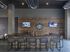 Contemporary lounge area with a stylish bar, comfortable seating, and dual wall-mounted televisions, ideal for socializing and relaxation.