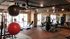 Modern fitness gym with state-of-the-art equipment including treadmills, exercise bikes, and weight machines, set in a spacious room with stylish flooring and large windows.