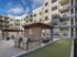Modern apartment courtyard featuring outdoor grills, comfortable seating under pergolas, and a well-maintained bocce ball court.