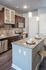Modern kitchen with granite countertops, stainless steel appliances, and elegant pendant lighting, perfect for culinary enthusiasts.