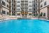 Luxurious apartment complex featuring a stunning pool, elegant architecture, and relaxing poolside lounge chairs.