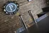 Chic industrial bar setting with a sleek countertop and polished metal beer taps, highlighted by a rustic wood-paneled wall featuring a stylish illuminated sign.