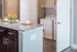 Modern kitchen island with granite countertops, elegantly set for a meal beside a convenient in-unit laundry area.