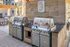 Modern outdoor grilling station with sleek stainless steel BBQs, set in a stylish patio ideal for entertaining.
