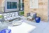 Chic outdoor lounge area featuring stylish wicker furniture with plush cushions, a sleek metallic coffee table, and modern blue accent tables, perfect for relaxation and entertaining.