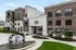 Elegant apartment complex with modern brick facade and landscaped entrance featuring a stylish fountain.