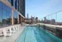 Luxurious rooftop pool surrounded by sleek architecture with stunning city skyline views.