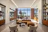 Luxurious and spacious living room with modern furniture, large windows offering panoramic city views, and elegant decor.