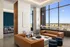 Modern lounge area with large windows, elegant leather sofas, stylish decor, and panoramic city views, creating a luxurious and inviting atmosphere.