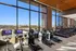 Modern gym with panoramic city views, featuring state-of-the-art exercise bikes and elliptical machines for a premium workout experience.