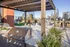 Stunning rooftop patio with modern grill area and lush greenery, offering breathtaking city skyline views.