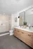 Elegant bathroom with a modern double vanity, sleek glass shower, and stylish tiles.