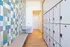 Modern apartment entryway featuring sleek lockers, colorful tiled accent wall, and chic wooden flooring for a stylish welcome.