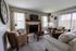 Cozy living room with elegant decor featuring a fireplace, plush seating, and modern touches, inviting natural light through large windows.