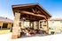 Charming outdoor pavilion with rustic wooden beams and picnic tables, perfect for social gatherings in a sunny apartment community.
