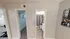 Modern apartment hallway featuring entrance to a well-organized walk-in closet and a stylish bathroom with elegant decor.