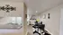 Modern dining area with elegant decor, featuring a stylish black dining set, cozy open kitchen, and chic wall art.