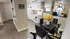 Bright and inviting kitchen and dining area with modern decor, featuring vibrant yellow flower centerpiece and sleek black dining set.