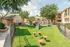Charming apartment complex with family-friendly playground set amidst lush green spaces and vibrant landscaping.