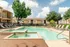 Inviting apartment community pool area with sun loungers, surrounded by lush greenery and modern architecture, perfect for relaxation.