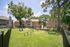 Charming apartment complex with lush green landscaping, a playful children's playground, and elegant balcony views.
