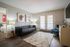 Inviting living room with elegant decor, cozy gray sofa, soft area rug, and sunlit French doors leading to a serene view.