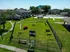 Charming apartment complex with a well-maintained dog park featuring agility equipment, lush green spaces, and inviting outdoor seating.