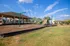 Inviting playground with swings and slides next to a spacious covered picnic area, perfect for family gatherings under a clear blue sky.
