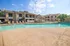Inviting apartment complex with a sparkling outdoor pool, surrounded by comfortable lounge chairs and lush greenery, perfect for relaxation.