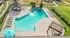 Inviting outdoor pool area with a stylish pergola, cozy gazebo, and lush green surroundings.