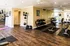 Inviting fitness center with modern equipment, mirrored walls, and polished wood flooring for a dynamic workout experience.