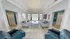 Elegant living room with high ceilings, stylish sofas, and a glass coffee table creating a luxurious ambiance.