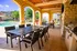 Luxurious outdoor patio with elegant dining setup overlooking a pristine swimming pool, perfect for entertaining and relaxation.