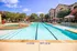 Inviting outdoor pool area with crystal-clear water, surrounded by lush landscaping and elegant residential buildings, perfect for leisure and relaxation.