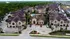 Aerial view of an elegant, well-maintained apartment complex surrounded by lush greenery, featuring modern architecture and a central swimming pool for perfect relaxation.