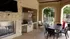 Inviting outdoor patio with modern grill, elegant stone fireplace, and stylish dining area, perfect for entertaining and relaxation.