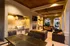 Chic outdoor patio featuring a modern barbecue setup, cozy seating with plush sofas, and warm ambient lighting under a stylish wooden ceiling.