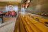 Elegant game room with a polished shuffleboard table, vibrant orange chairs, and modern wall decor, perfect for entertainment and relaxation.