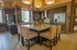 Luxurious modern kitchen with elegant granite island, cozy seating, stainless steel appliances, and ambient lighting.