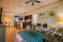 Modern open-concept living room with vibrant decor, featuring a sleek kitchen and cozy seating area with plush pillows.