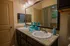 Elegant bathroom featuring dual sinks with granite countertops and modern fixtures, accented by stylish turquoise decor.