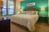 Inviting bedroom with plush white bedding, elegant decor, and warm lighting creating a tranquil retreat.