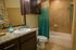 Elegant bathroom featuring a granite countertop, modern fixtures, and stylish teal-accented shower curtain.